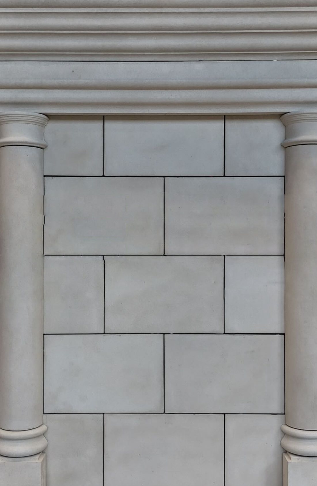 Architectural precast columns, capitals and entablature in a crème smooth finish, displayed in the BBS showroom